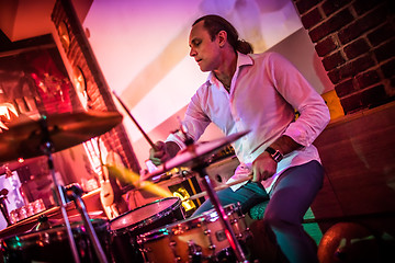 Image showing Drummer playing on drum set on stage.