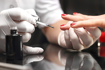 Image showing Well-groomed female hands, a colorful manicure Red nail polish, 