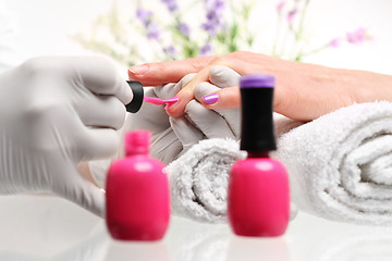 Image showing Hybrid manicure, beauty salon Styling nail color nail polish Beautician painting nailsStyling nail color nail polish Pastel nails pink nail polish