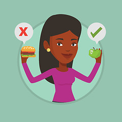 Image showing Woman choosing between hamburger and cupcake.