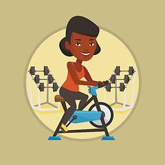 Image showing Young woman riding stationary bicycle.