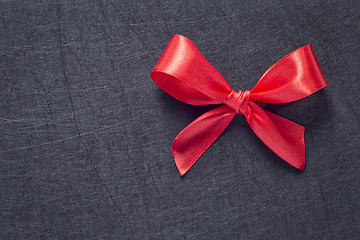 Image showing Red bow on black textured background