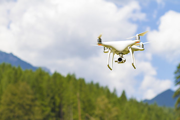 Image showing White drone flying above mountains.