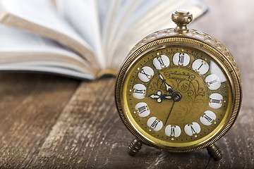 Image showing Holy Bible and alarm clock on wood table