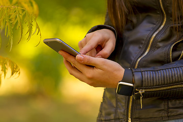 Image showing Young girl using smart phone in the park