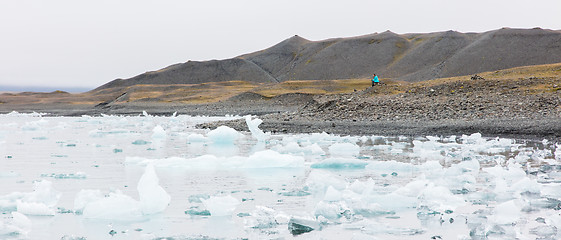 Image showing Woman sitting on the beach at Jokulsarlon glacier lagoon - Icela