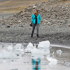 Image showing Woman walking over the beach at Jokulsarlon glacier lagoon - Ice