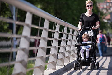 Image showing mother pushed her baby daughter in a stroller