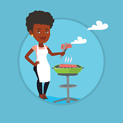 Image showing Woman cooking steak on barbecue grill.