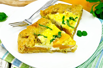 Image showing Pie of pumpkin and cheese in white plate on light board