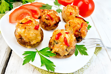 Image showing Champignons stuffed with meat and peppers in plate on board