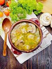 Image showing Soup with meatballs and mushrooms in clay bowl on board top