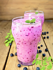 Image showing Milkshake with blueberries in two glasses on board