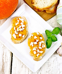 Image showing Bruschetta with pumpkin and cheese in plate on board top