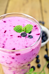 Image showing Milkshake with blueberries in glass on wooden board