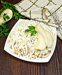 Image showing Salad of squid and pears with parsley on board