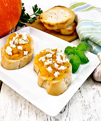 Image showing Bruschetta with pumpkin and cheese in white plate on board