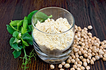 Image showing Flour chickpeas in glassful with peas on dark board