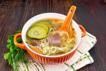 Image showing Soup with zucchini and noodles in red bowl on board