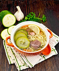 Image showing Soup with zucchini and noodles in bowl on napkin