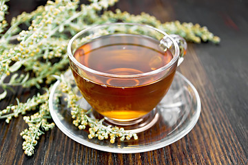 Image showing Tea with gray wormwood in glass cup on table