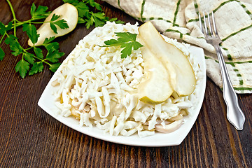 Image showing Salad of squid and pears with towel on dark board