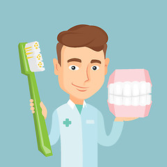 Image showing Dentist with dental jaw model and toothbrush.