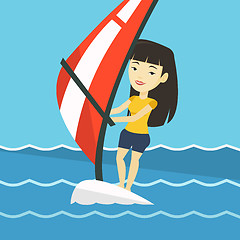 Image showing Young woman windsurfing in the sea.