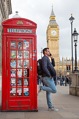 Image showing Man talking on mobile phone, red telephone box and Big Ben. London, England