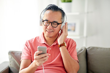 Image showing man with smartphone and headphones at home