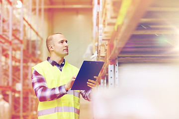 Image showing man with clipboard in safety vest at warehouse