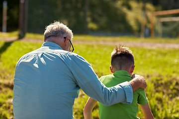 Image showing grandfather and grandson hugging outdoors