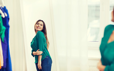 Image showing happy woman posing at mirror in home wardrobe