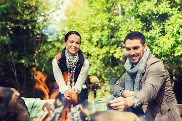 Image showing happy couple roasting marshmallow over camp fire