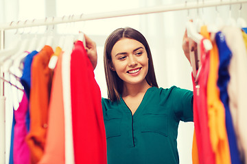 Image showing happy woman choosing clothes at home wardrobe