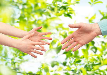 Image showing father and child hands over green leaves