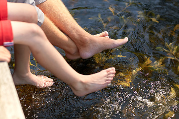 Image showing grandfather and grandson sitting on river berth