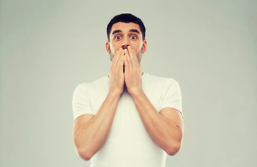 Image showing scared man in white t-shirt over gray background