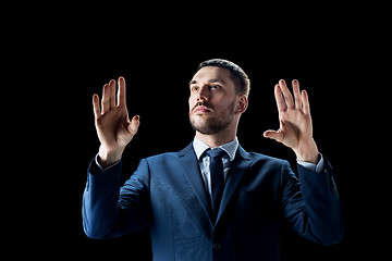 Image showing businessman in suit over black