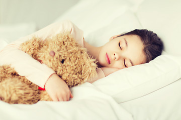 Image showing girl sleeping with teddy bear toy in bed at home