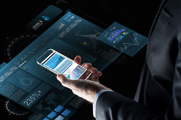 Image showing close up of businessman with charts on smartphone