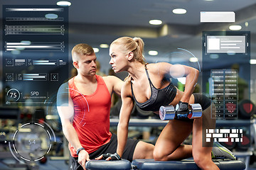 Image showing young couple with dumbbell flexing muscles in gym