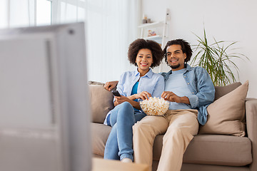 Image showing smiling couple with popcorn watching tv at home