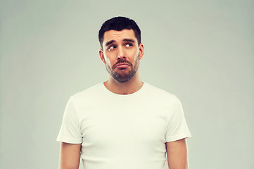 Image showing unhappy young man over gray background