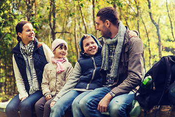 Image showing happy family sitting on bench and talking at camp