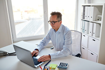 Image showing businessman in eyeglasses with laptop office