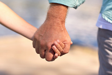 Image showing senior man and child holding hands