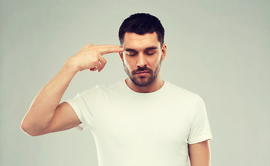 Image showing man making finger gun gesture over gray background