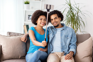 Image showing happy couple with smartphone taking selfie at home