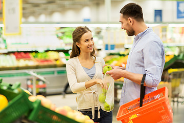 Image showing happy couple buying apples at grocery store